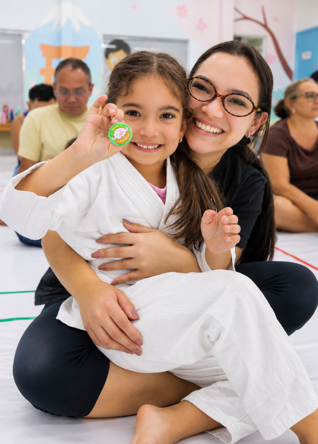 Aluna sorrindo com medalha, abraçada por instrutora